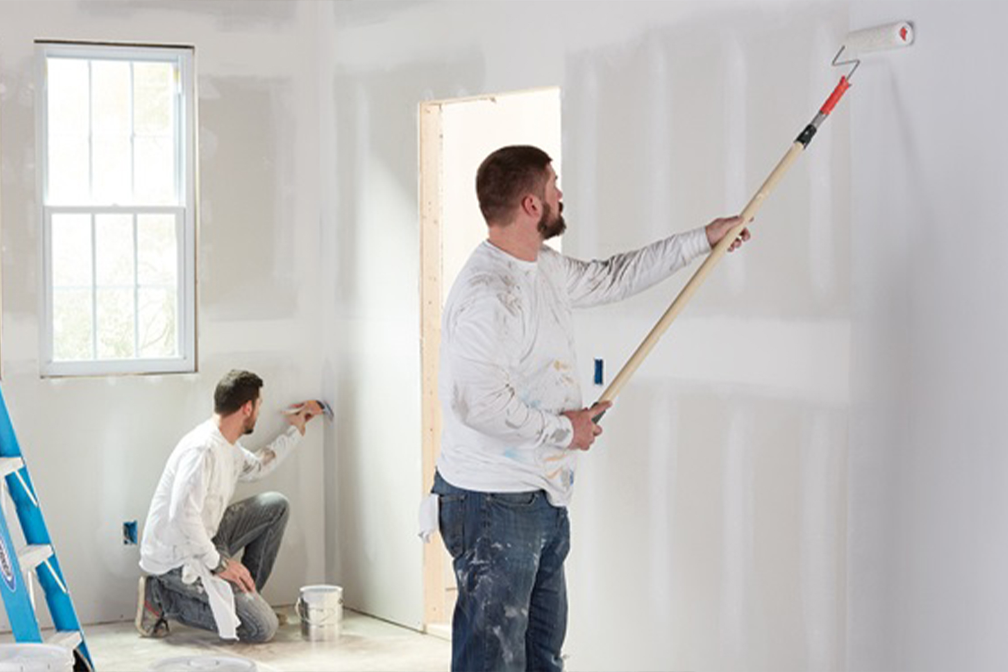 Men painting empty home interior